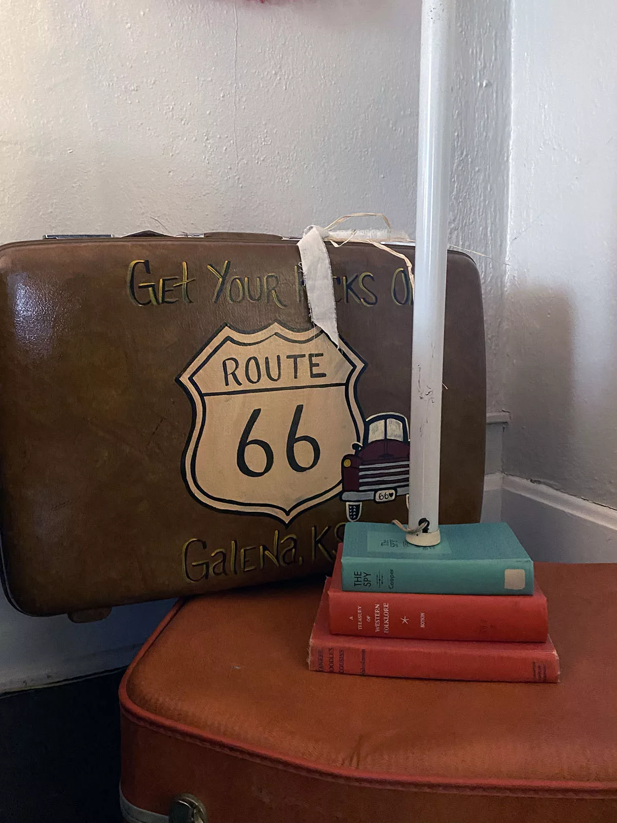 Route 66 painted suitcase and stack of books at the Old Riverton Post B&B in Riverton, Kansas