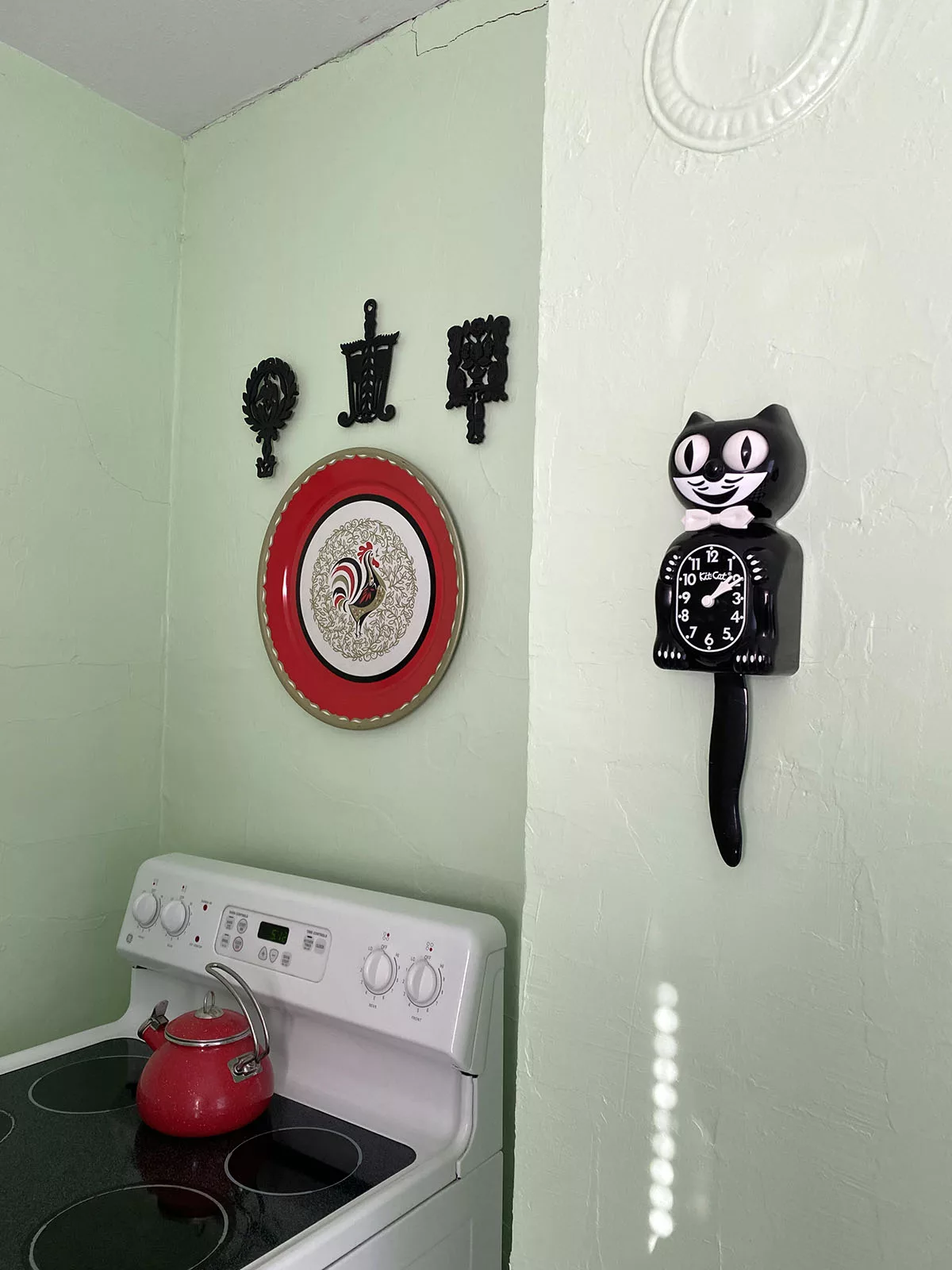 Kitchen wall with cat clock and stove at the Old Riverton Post B&B in Riverton, Kansas