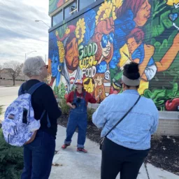 Women standing in front of mural during Urban Hikes KC tour of Strawberry Hill in Kansas City, Kansas