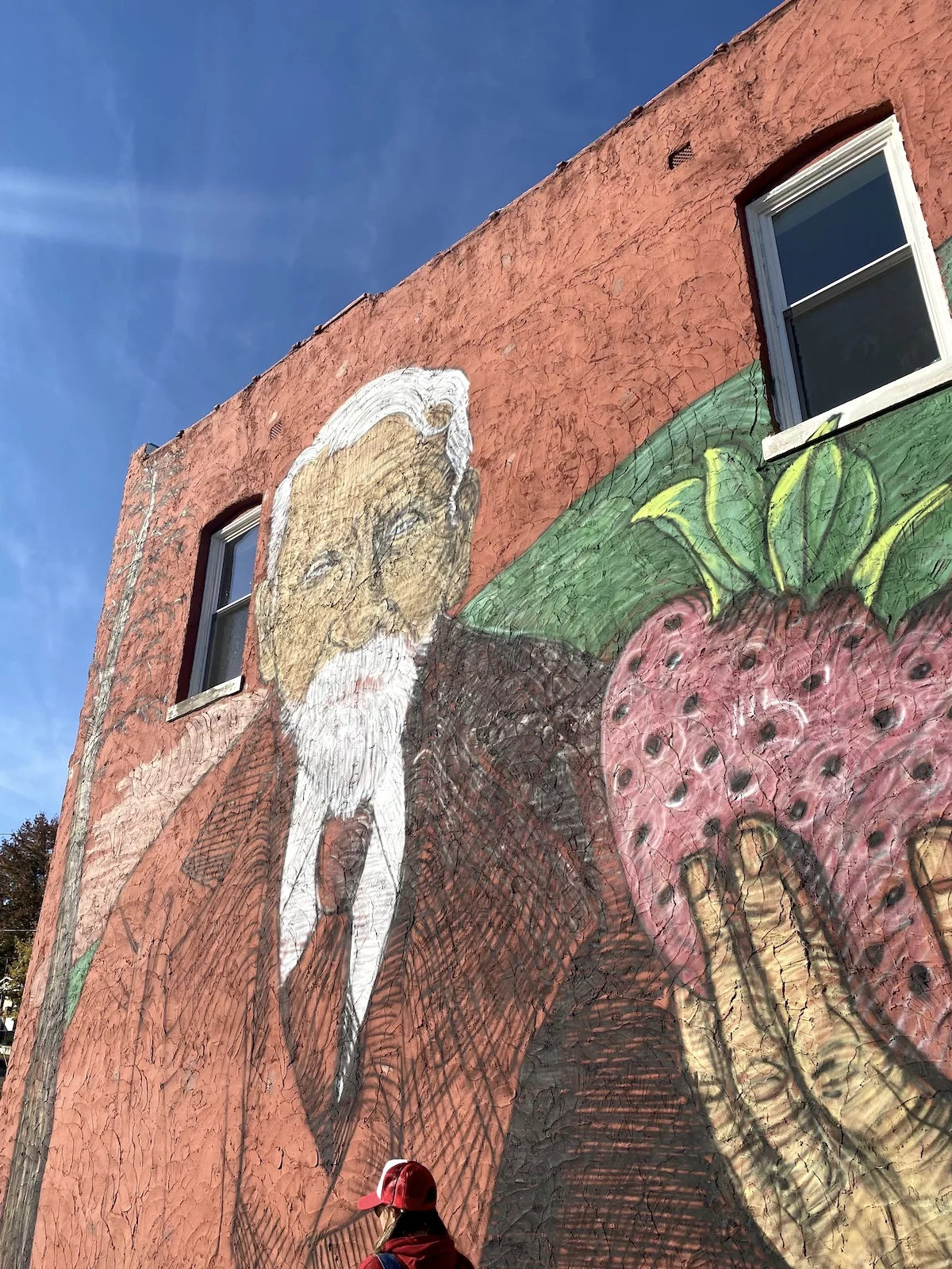 Mural of man holding strawberry near Splitlog Coffee Co. in Strawberry Hill neighborhood of Kansas City, Kansas