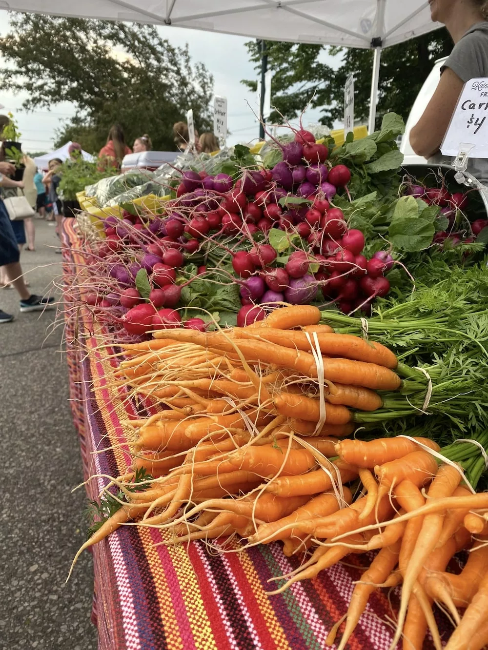 Table of carrots and radishes at the Cedar Falls Farmers' Market in Cedar Falls, Iowa
