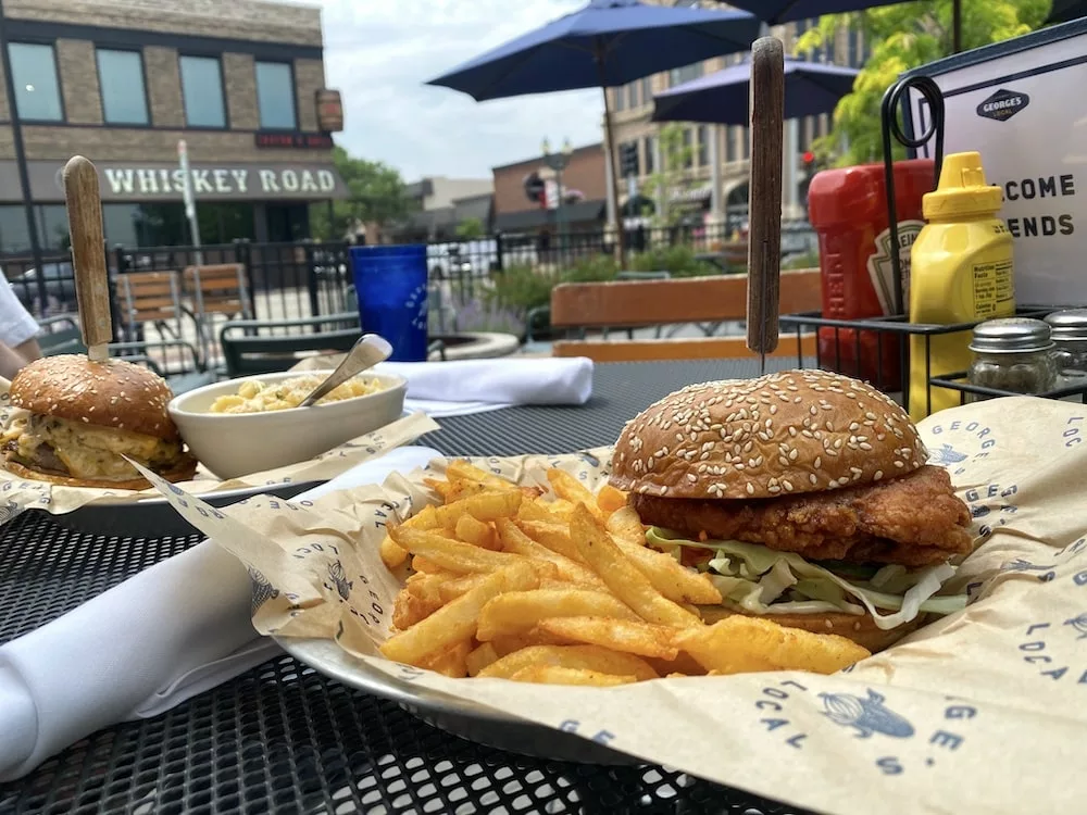 Chicken sandwich with fries and burger with mac and cheese on the patio of George's Local in Cedar Falls, Iowa