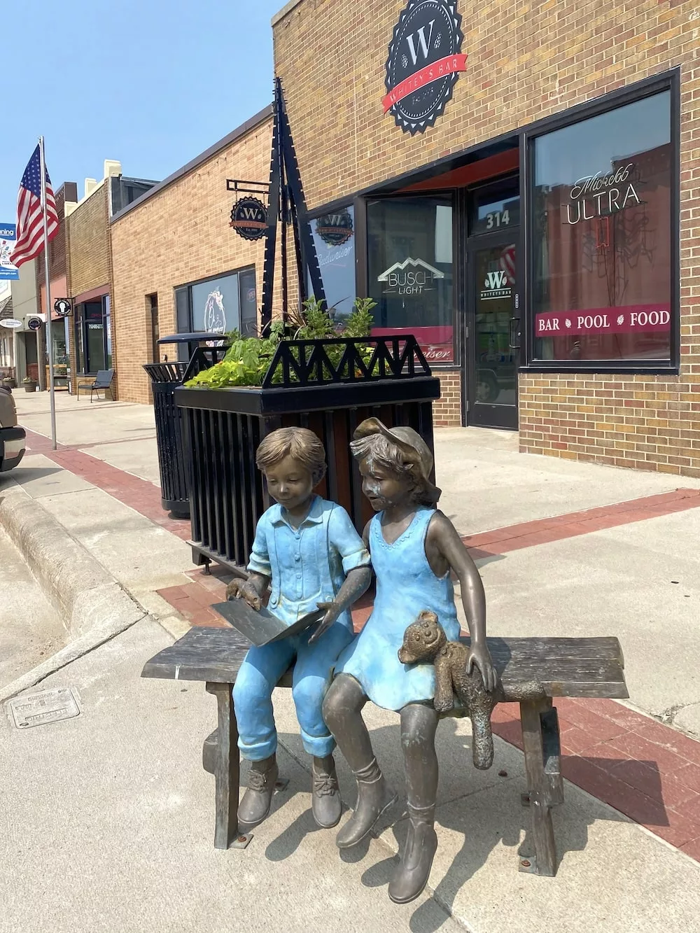 Statue of two children on a bench in downtown Manning, Iowa